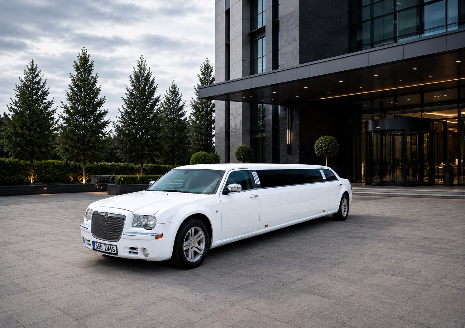 White stretch limousine parked in front of a luxury hotel — special occasions service