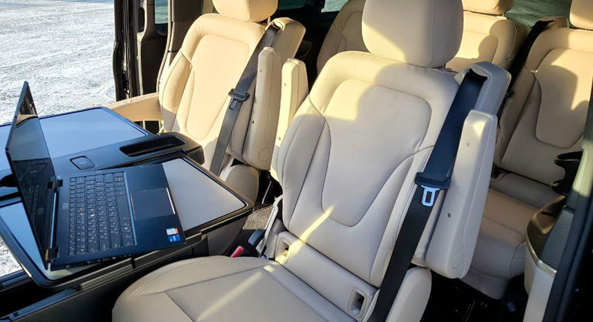 V-Class rear cabin with a fold-out table and a laptop, seats facing each other